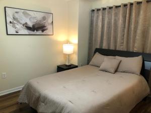 a small bedroom with a bed and a lamp at 4BR Cruise-Ready Home Walk to Moody Gardens Fenced Yard in Galveston