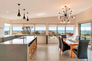 een grote keuken met een eettafel en stoelen en ramen bij Tranquility Bay of Fires in Binalong Bay