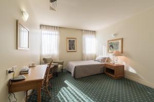 保尔罕希尔斯Mary MacKillop Spirituality Centre Baulkham Hills的配有床和书桌的酒店房间