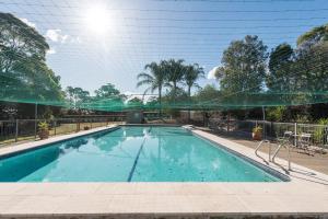 保尔罕希尔斯Mary MacKillop Spirituality Centre Baulkham Hills的环绕着绿色网的游泳池