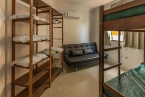 ボンビーニャスにあるEco Village Parkの二段ベッドとソファが備わるドミトリールームです。 +57枚の写真