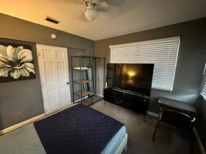 a bedroom with a bed and a flat screen tv at Downtown Private Deluxe Room in Orlando