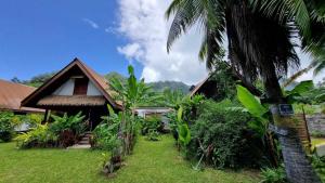 a house with a palm tree in front of it at MOOREA - Tropical Bungalow in Hauru