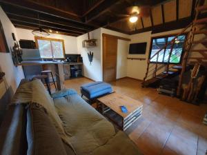 a living room with a couch and a table at MOOREA - Tropical Bungalow in Hauru