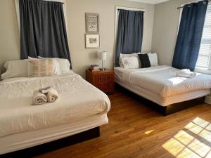 two beds in a bedroom with blue curtains at Lovely on Lorick-USC, Jackson, Pets, Wifi in Columbia