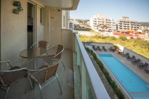 ボンビーニャスにあるEco Village Parkのバルコニー(テーブル、椅子付)、スイミングプールが備わります。