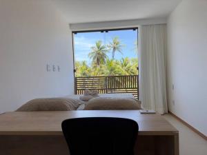 una camera da letto con due letti e una grande finestra di Village 2qts, frente e vista mar, praia de Imbassaí a Imbassai Altre 42 foto
