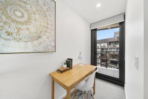 PhillipにあるPhillip 2-Bed: Chic Interiors Amazing Amenitiesの大きな窓のある客室で、デスクが備わります。