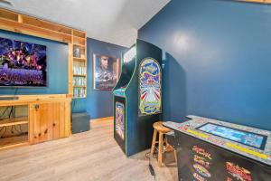 a room with a pinball machine and a television at Gray Fox Den Theater & Arcade, Hot Tub, Views in Gatlinburg
