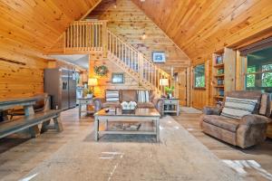 a living room with a staircase in a cabin at Gray Fox Den Theater & Arcade, Hot Tub, Views in Gatlinburg