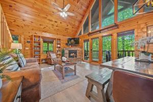 a living room with a fireplace in a log cabin at Gray Fox Den Theater & Arcade, Hot Tub, Views in Gatlinburg