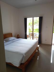 une chambre avec un grand lit et un balcon dans l'établissement Pulmo Residen Canggu, à Canggu 85 autres photos
