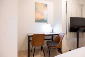 a desk with two chairs and a television in a room at Harbors Residence Yahiro in Tokyo +28 photos