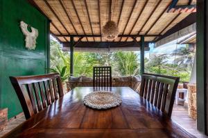 a dining room table with chairs and a wooden table at Family Oasis, 2 Bedrooms, Shared Pool, Garden, Rice Field View in Ubud