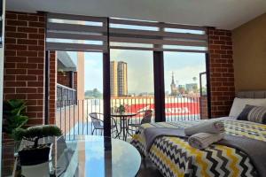 a balcony with two beds and a glass table at ¡Torre Modra Apartamento Moderno Atractiva Zona 4! in Guatemala