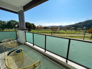 a balcony with two chairs and a view of a field at 家太幸福民宿 in Xingjian