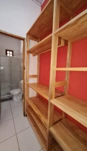 a room with wooden shelves in a bathroom with a toilet at Espaço Bem Bom in Andaraí