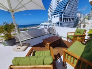 a balcony with chairs and a table and an umbrella at Bell Boutique and Spa Hotel in Tel Aviv