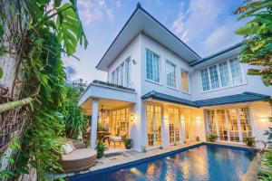 a house with a swimming pool in front of it at Viki Nest by SooBali 4BR in Umalas