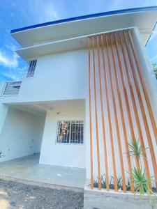 a white house with a wooden fence in front of it at RHM homestay in Naga