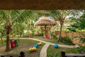 a playground with a play area with toys in the grass at Family Villa, Shared Pool, Garden, Rice Field & Jungle Views in Ubud