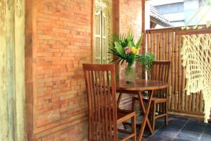 a wooden table with chairs and a vase of flowers on a patio at Family Villa, Shared Pool, Garden, Rice Field & Jungle Views in Ubud +12 photos