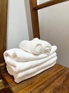 a stack of white towels sitting on a wooden shelf at Monday Guesthouse Hatyai in Hat Yai +89 photos