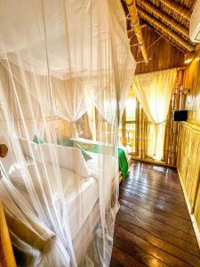 a bedroom with a bed covered in mosquito nets at Penida Bambu Green Villas in Nusa Penida