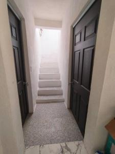 ein Flur mit Treppe in einem Gebäude mit zwei Türen in der Unterkunft Departamento linda vista in Guanajuato