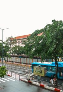 a blue bus driving down a city street at Skyline Studio by Ben Thanh, D1 in Ho Chi Minh City