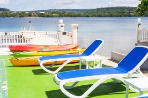 UtungakeWolfgramm Beachfront Motel的水面上放着几把椅子和几条船