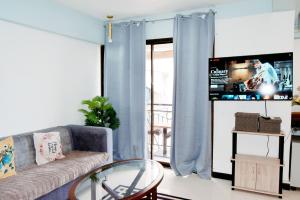 a living room with a couch and a tv at The Loft Nook in E-building Kiener Hills Condominium in Pusok