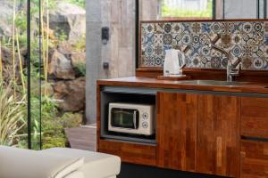 a bathroom with a microwave and a sink at Ceylon Jeju Pool Villa in Jeju