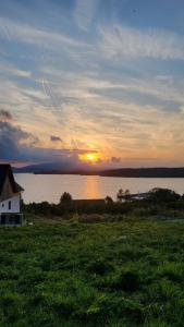 a sunset over a body of water with a house at Penzion Axiom in Frymburk