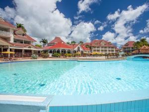a large swimming pool in front of a resort at Ti' Dominique à Pierre et Vacances in Sainte-Luce