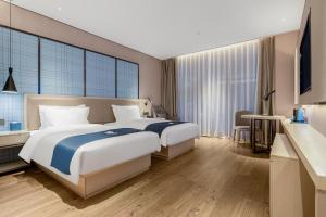 una camera d'albergo con un grande letto e una TV di Echarm Hotel Changsha Provincial Government Desiqin Branch a Changsha
