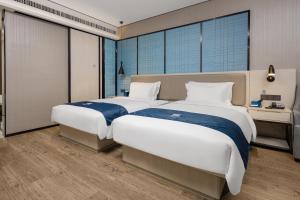 due letti in una stanza con ampie finestre di Echarm Hotel Changsha Provincial Government Desiqin Branch a Changsha