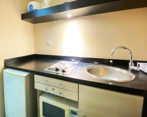 a kitchen with a sink and a counter top at Cozy 1BR Apartment at Braga City Walk By Travelio in Bandung