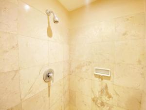 a shower with a shower head in a bathroom at Cozy 1BR Apartment at Braga City Walk By Travelio in Bandung +7 photos