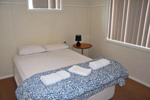 Un dormitorio con una cama con dos toallas encima. en Clarkes Flat 2, en South West Rocks