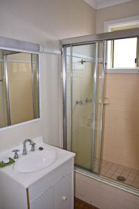 un baño con lavabo y ducha en Clarkes Flat 2, en South West Rocks