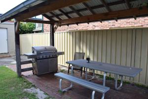 una mesa de picnic, una parrilla y un banco de picnic en Clarkes Flat 4, en South West Rocks
