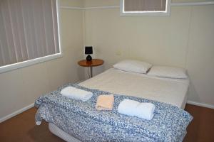 1 dormitorio con 2 camas y toallas. en Clarkes Flat 1, en South West Rocks