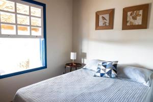 a bedroom with a bed with a pillow and a window at Recanto da Seriema in Gonçalves