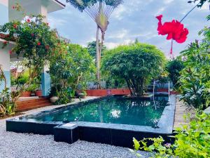 een zwembad midden in een tuin bij Villa Jacaranda in Varkala