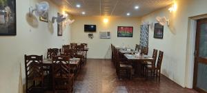 a restaurant with wooden tables and chairs in a room at Ranthambhore Tiger Niwas in Sawāi Mādhopur