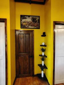 a room with a door and a yellow wall at Estancia Las Golondrinas in Tecpán Guatemala +21 photos