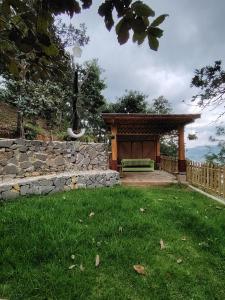 a gazebo with a bench in a yard at Estancia Las Golondrinas in Tecpán Guatemala