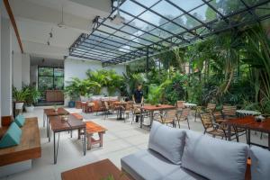 a person standing in a restaurant with tables and chairs at Onederz Siem Reap in Siem Reap