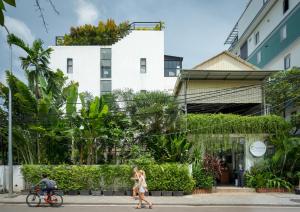 a couple walking down the street in front of a building at Onederz Siem Reap in Siem Reap